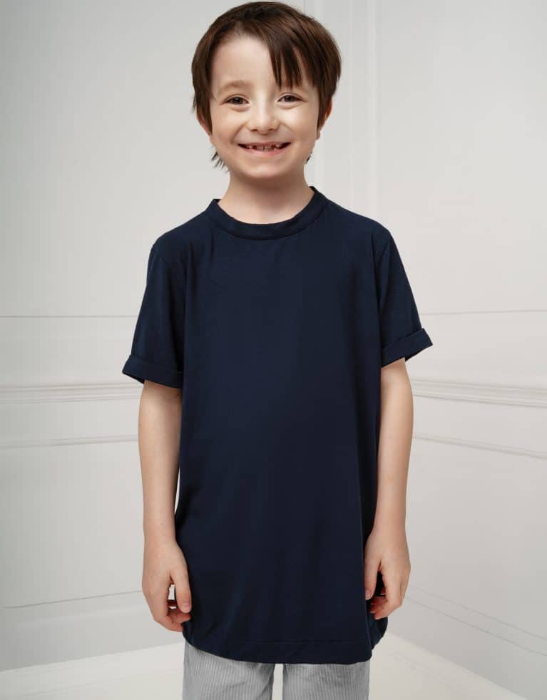 A young neurodivergent boy with brown hair smiles at the camera. he is wearing a dark blue fidget-t t-shirt that is slightly too big for him.